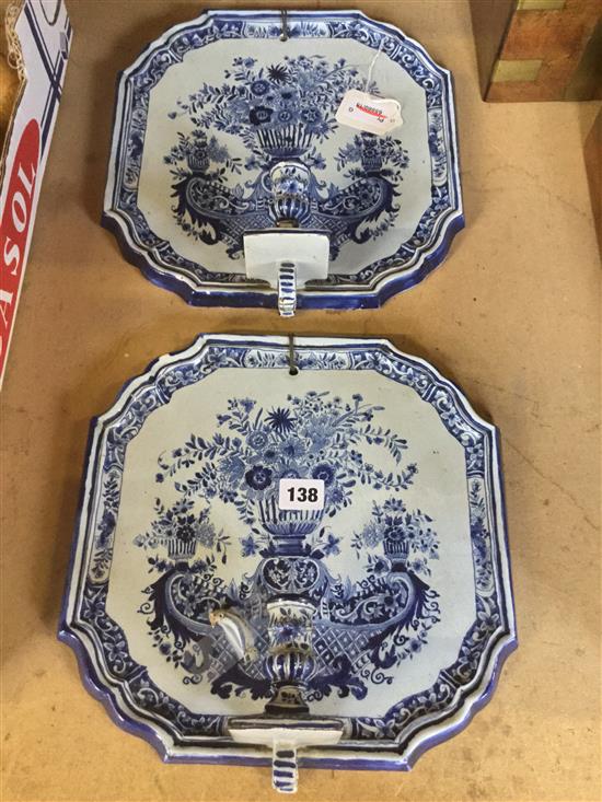 Pair Delft pottery wall plaques fitted candle sconces, decorated flowering urns (one a.f.)